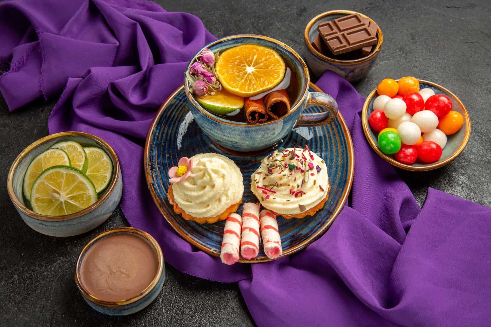Sweet deserts in a plate. There is cupcakes, waffle sticks and two hot chocolates